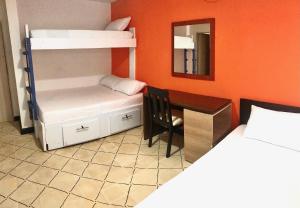 巴兰基亚La Quinta Bacana La Campiña的一间卧室配有一张双层床、一张桌子和一张双层床。