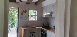 圣艾尼昂La petite maison的厨房配有柜台、水槽和窗户