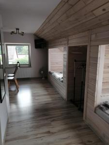 KarsinPAKLADA 3 Pokój typu studio的一间铺有木地板的客房和一间配备有两张床的客房