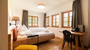 多比亚科Natura Boutique Chalet Wellness SPA的卧室配有一张床、一张书桌和窗户。