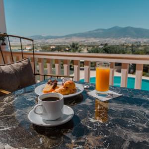 Néon RýsionHeaven Hotel Thessaloniki Airport的餐桌,咖啡,羊角面包和橙汁