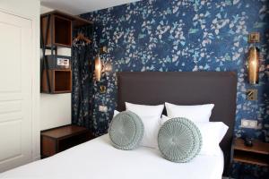 巴黎莫里斯格兰德大道酒店的一间卧室配有一张带白色枕头和蓝色壁纸的床。