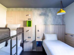 梅里尼亚克greet Hotel Bordeaux Aeroport的客房设有两张双层床和绿色橱柜。