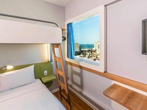 福塔莱萨Ibis Budget Fortaleza Praia de Iracema的一间卧室配有双层床和窗户。