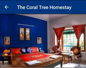 阿格拉The Coral Tree Boutique Homestay的一间设有床铺和蓝色墙壁的客房