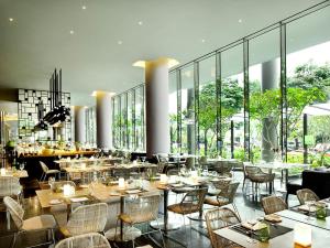 新加坡PARKROYAL COLLECTION Pickering, Singapore的餐厅设有桌椅和大窗户。