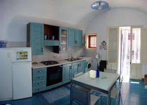 圣维托罗卡波Casa Cipolla的厨房配有蓝色橱柜和白色冰箱