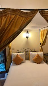马拉喀什Riad Hôtel Belleville Marrakech的一间卧室配有一张带天蓬的白色床
