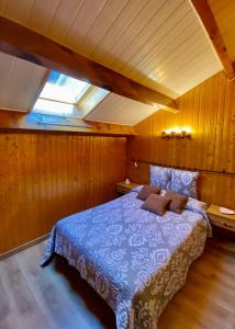 波泰皮莫朗Charmant T3 "les Cerdans"的一间设有蓝色床的卧室,位于带木墙的房间