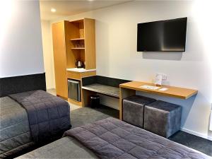 特卡波湖戈德利酒店的酒店客房设有一张床、一张书桌和一台电视机。