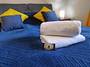 扎科帕内Apartamentylove - Apartament Oliwia的蓝色的床,配有蓝色和黄色枕头以及毛巾