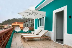 丰卡连特德拉帕尔马Casa Salazar的一个带两把椅子和一把遮阳伞的庭院