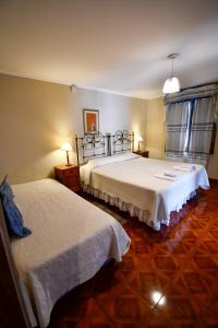 萨尔塔Hostal El Cerrito的酒店客房设有两张床和两盏灯。