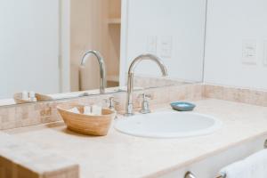 埃斯特角城卡拉精品酒店的浴室的柜台设有水槽和镜子