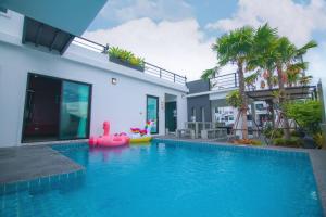 华欣บ้าน Spring Vintage Pool Villa ใจกลางเมืองหัวหิน ใกล้หาด的一座房子,里面设有一座游泳池,上面有粉红色的浮子
