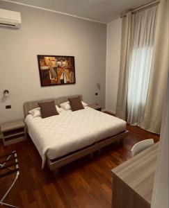 佩罗Relais Villa Rosa的一间卧室配有一张带白色床单的大床