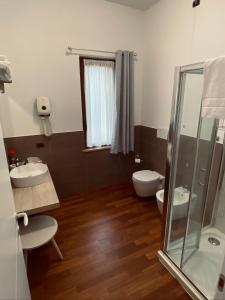 佩罗Relais Villa Rosa的浴室配有2个盥洗盆、卫生间和淋浴。