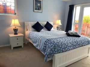 皇后镇Greengables B&B的一间卧室配有一张床、两盏灯和一个窗户。