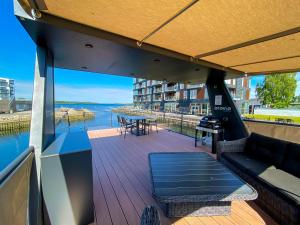 尼克宾法尔斯特MarinaVilla的阳台配有沙发和桌子,享有水景。