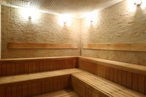 别府KAMENOI HOTEL Beppu的一间设有木凳和砖墙的桑拿浴室