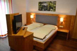 穆劳卡费胡贝酒店的一间卧室配有一张木架床和一台电视。