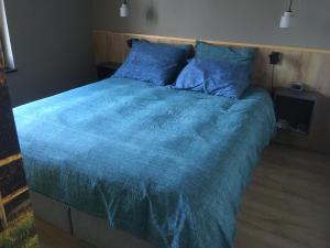 法尔肯堡Auberge Sans Souci的一间卧室配有一张带蓝色棉被的大床