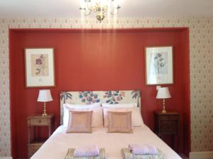 Saint-Germain-de-ConfolensLa Grange Terrou的一间卧室设有一张红色墙壁的大床
