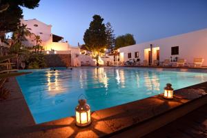 利帕里戈多帕多公园酒店的一座带灯的游泳池,位于大楼旁