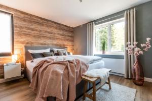 韦耶达Harzfalke Apartment - Ankommen und wohlfühlen.的卧室设有木墙