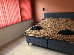 登德尔蒙德ROS'a tourist & business appartment的一间卧室设有一张豹纹床和窗户。