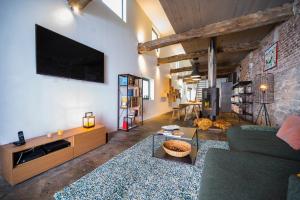 列日L'atelier de Liège: Tranquillité & Effervescence的客厅配有沙发和砖墙电视
