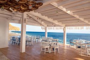 沙姆沙伊赫Sunrise Remal Beach Resort的一间带桌椅的海景餐厅