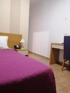 贝雅霍斯佩达利娅多纳玛丽亚旅馆的一间卧室配有一张紫色的床和一张书桌