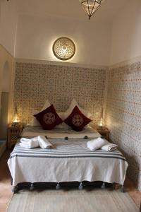 马拉喀什耶南埃尔卡迪摩洛哥传统庭院住宅的一间卧室配有一张带红色枕头的大床