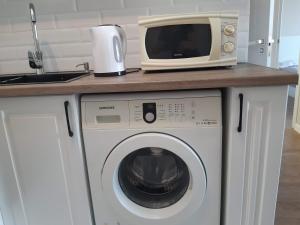 阿拉木图Квартира на речке Есентайка的洗衣机上的一个微波炉