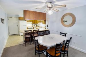 默特尔比奇2BR, 2Bath condo Oceanfront Getaway with pool的厨房以及带白色桌椅的用餐室。