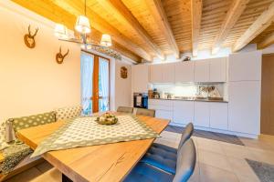 阿莱盖Charming Civetta的厨房以及带木桌和椅子的用餐室。