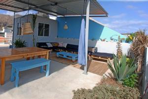 塔拉法尔Cloud7 Beach Hostel的天井配有桌子、蓝色长椅和桌子