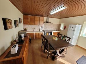 Faja GrandeCasa Fagundes的厨房配有桌椅和冰箱。