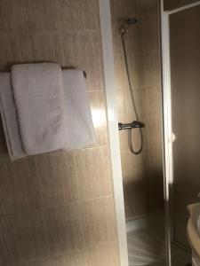 瓦尔德莫罗Hostal De La Rosa的带淋浴和白色毛巾的浴室