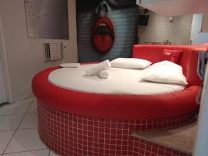巴西利亚Hotel 1001 Prime - Ceilândia的红色床头板的房间里一张红色的大床