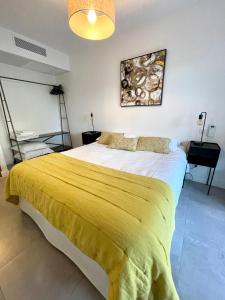 蒙蒂塞洛Appartement 1 chambre Monte Stella的一间卧室配有一张带黄色毯子的大床