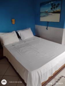 阿拉夏奇巴海滩Pousada Mar de Araçatiba的一张大床,位于一个蓝色的墙壁内