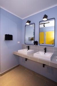 维纳德马NOT FOUND Hostel的一间带两个盥洗盆和大镜子的浴室