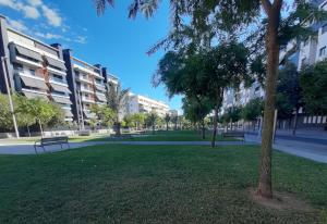 科尔多瓦Piso céntrico con piscina,parking y jacuzzi的建筑前方有长椅和树木的公园