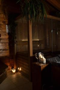 奇斯泰尼诺Mini spa in chalet bosco的一间设有桑拿浴室、蜡烛和酒杯的房间