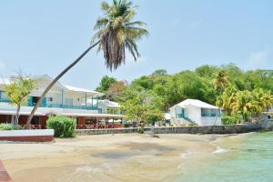 CalliaquaMariners Hotel的享有海滩美景,设有房屋和棕榈树