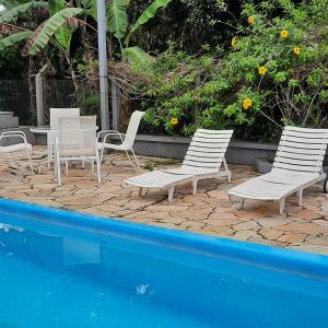 伯迪亚哥Santa Hospedaria Beach的一组椅子和一张桌子,旁边是游泳池