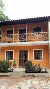伦索伊斯Casa Laranja Lençóis - BA的一座橙色房子前面有窗户和植物