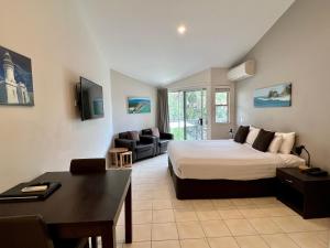 拜伦湾拜伦湾海滨小屋公寓式酒店的一间卧室设有一张床和一间客厅。